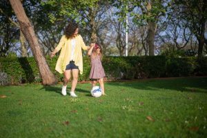 mum and daughter playing with soccer ball